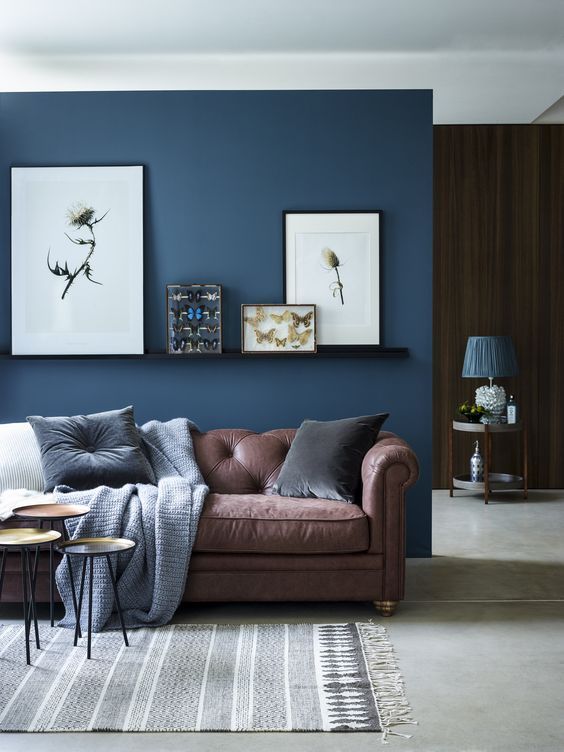 chic seating area with a brown sofa and a navy accent wall and