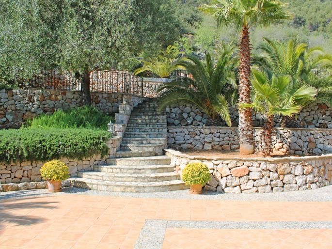 Natural stone walls give this outdoor living area & terrace in