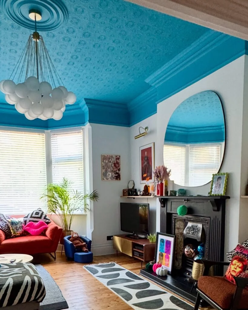Turquoise painted ceiling with wave patterns and pendant light